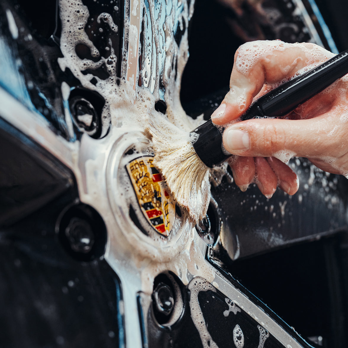 car detailing brush on Porsche badge